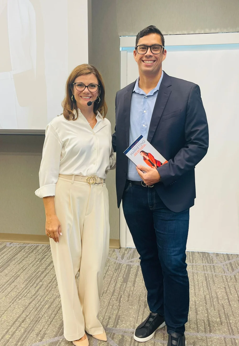 Bianca Lincks and Thiago Ataide, broker and founder of WRA Business & Real Estate, with the book Real Estate Marketing